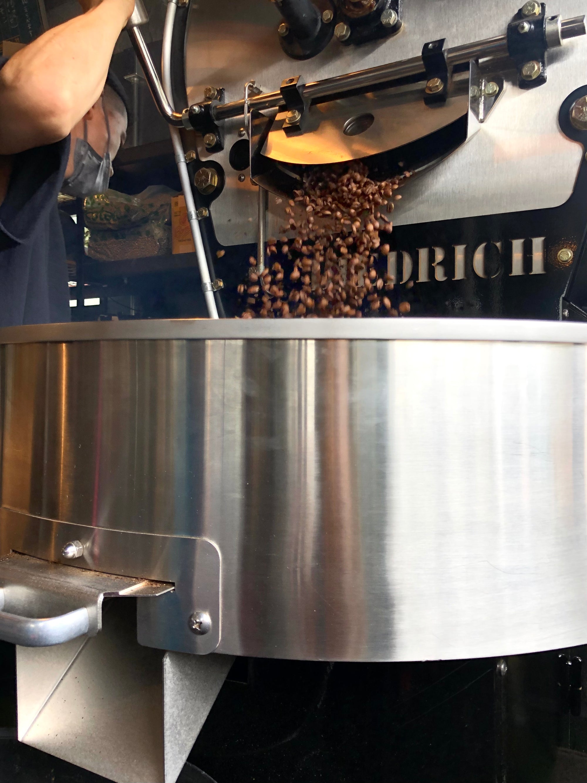 Freshly roasted specialty, single origin coffee beans tumbling out of a Diedrich coffee roaster. The beans can be shipped internationally.
