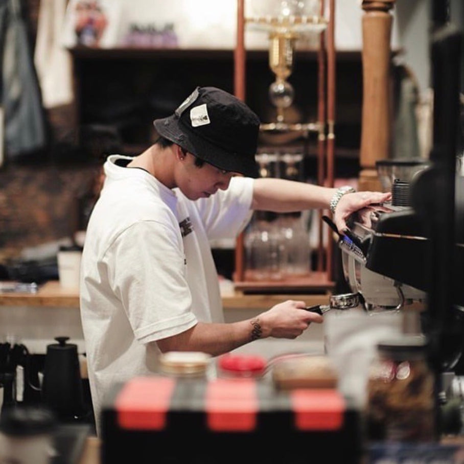 A cool looking barista preparing an espresso using specialty roasted, single origin beans from Dark Arts Coffee, Japan